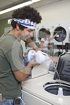 Man Pouring Liquid Solution In Washing Machine