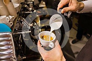 Man Pouring Milk into Coffee Making Espresso.