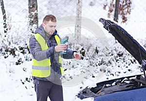 Man pouring motor oil to car engine.