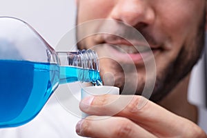 Man Pouring Mouthwash In To Cap