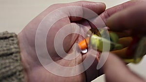 Man pouring pills from the jar on his palm