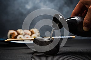 Man pouring sake into sipping bowl