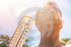 Man pouring water on his head in extreme heat, Thermometer in summer day shows or indicate high temperature