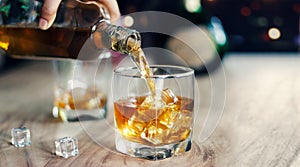 Man pouring whiskey into glasses, drinking alcoholic beverage photo