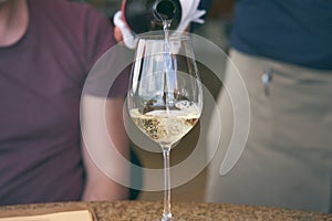 Man pouring wine into glass in a restaurant. Waiter serving drink. Wine tasting concepts