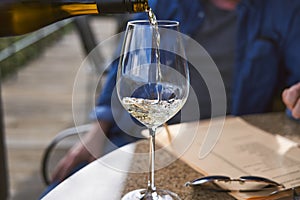 Man pouring wine into glass in a restaurant. Waiter serving drink. Wine tasting concepts