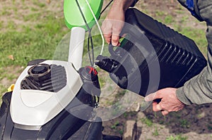 A man pours gasoline from the canister into the cultivator tank