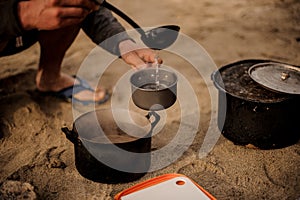 Man pours soup in the metal pan photo