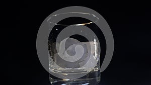 A man pours ice into a glass close-up on a dark background