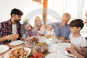 A man pours juice for his family, who gathered at a festive table for Thanksgiving