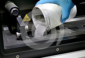 Man pours metal powder into the chamber of a laser sintering machine