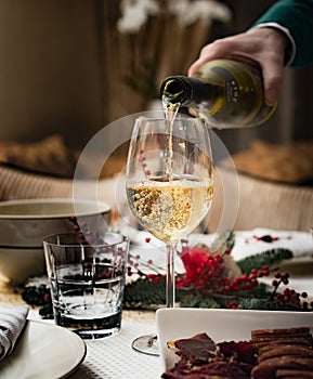 Man pours white wine into a glass