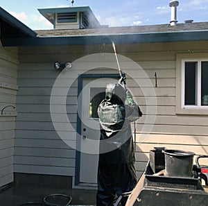 Man power washing a home.