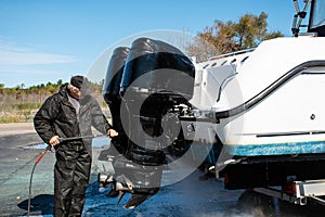 Man power washing outboard motors