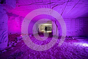 A man with powerful flashlights explores dangerous tunnels, old abandoned quarry mines near the city of Sataniv, Ukraine. Cracks