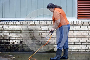 Man powerwashing mold of wall - DIY