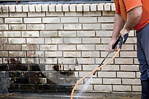 Man powerwashing mold of wall - DIY