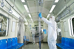 Man in PPE suits with mask wiping down surface to prevent pandemic of coronavirus