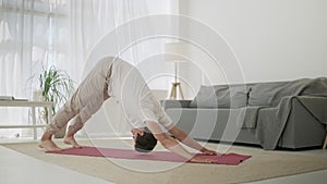 Man Practice Yoga Sun Salutation. Body Care Morning Routine at Cozy Interior Room Indoor. Down and Up Facing Dog Pose