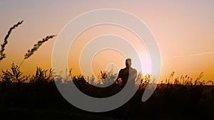 A man practices yoga at sunset a man meditates in nature