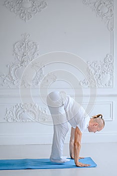 Man practicing advanced yoga against a white background