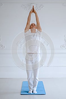 Man practicing advanced yoga against a white background