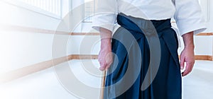 Man practicing aikido in a dojo background.