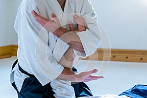 Man practicing aikido in a dojo background.