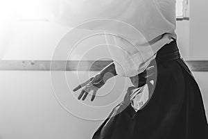 Man practicing aikido in a dojo background.