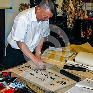 A man practicing the ancient art of Chinese calligraphy