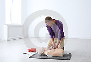 Man practicing first aid on mannequin