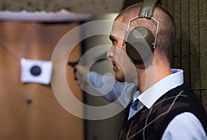 Man practicing handgun shooting at target at pistol range