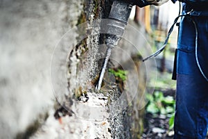 Man practicing his skills with pneumatic drill at demolishing walls