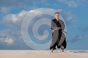Man practicing Japanese martial art - iaido in the desert