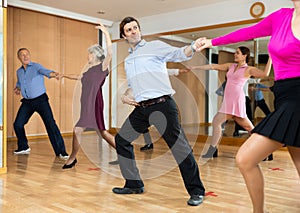 Man practicing jitterbug with female partner in dance studio