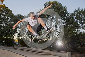 Man practicing radical skate board jumping and enjoying tricks and stunts in concrete half pipe skating track in sport and healthy photo