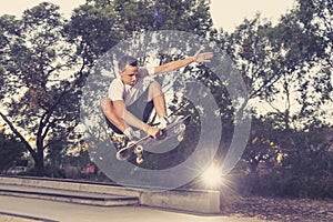 Man practicing radical skate board jumping and enjoying tricks and stunts in concrete half pipe skating track in sport and healthy