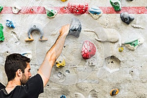 Man practicing rock climbing on artificial wall indoors. Active lifestyle and bouldering concept