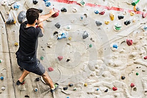 Man practicing rock climbing on artificial wall indoors. Active lifestyle and bouldering concept