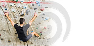 Man practicing rock climbing on artificial wall indoors. Active lifestyle and bouldering concept with copy space
