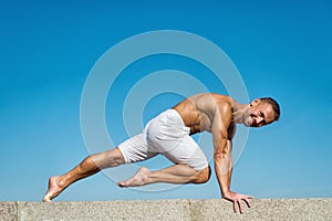 Man practicing yoga blue sky background. Reached peace of mind. Meditation and yoga concept. Yoga helps find balance