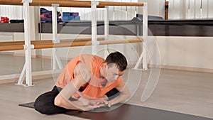 Man practicing yoga in the hall.Bright Studio with large Windows and mirrors. Sportswear