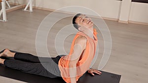 Man practicing yoga in the hall.Bright Studio with large Windows and mirrors. Sportswear