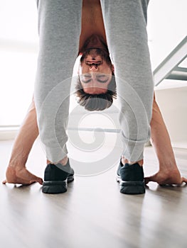 Man Practicing Yoga At Home Doing Sun Salutation Routine