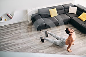 Man Practicing Yoga At Home Doing Sun Salutation Routine