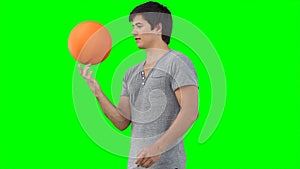 A man practises spinning a basketball on his finger