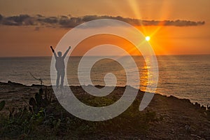 A Man Praising or Worshiping by Ocean at Sunrise photo