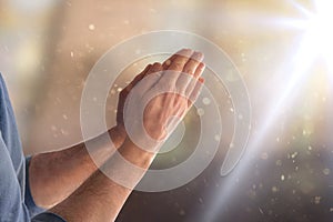 Man praying in church with hands with palms together flash