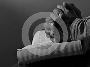 man praying with hand on bible on grey background with people stock image stock photo