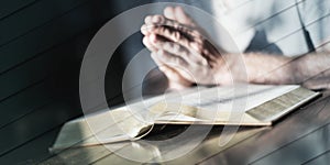 Man praying hands on a bible, geometric pattern